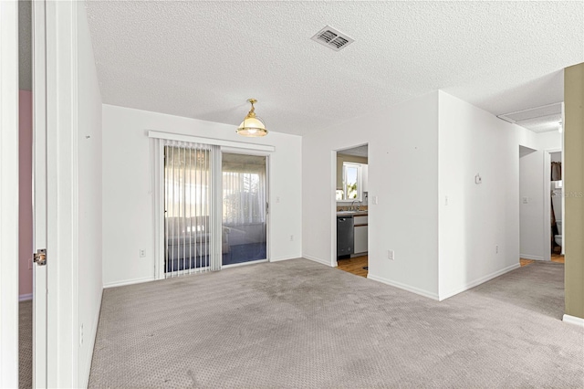 carpeted spare room with a textured ceiling