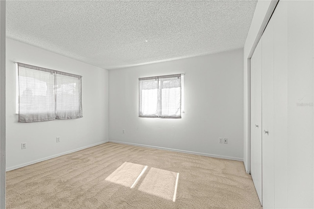 carpeted empty room featuring a textured ceiling