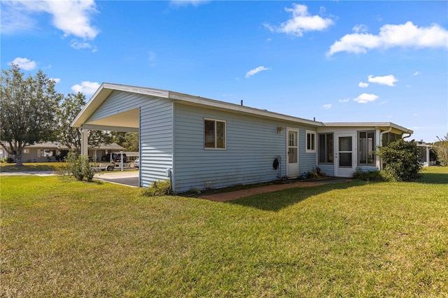 back of house with a sunroom and a lawn