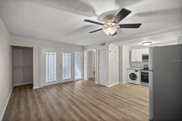 kitchen featuring ceiling fan, washer / clothes dryer, appliances with stainless steel finishes, white cabinets, and light wood-type flooring