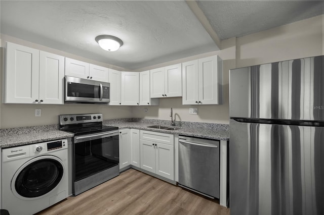 kitchen featuring washer / clothes dryer, sink, white cabinets, and stainless steel appliances