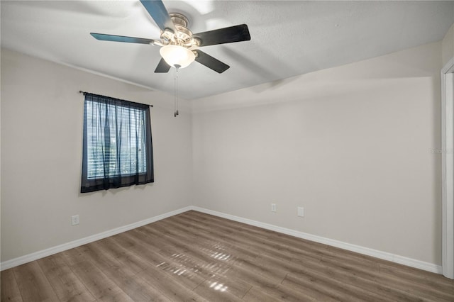 spare room with hardwood / wood-style floors and ceiling fan