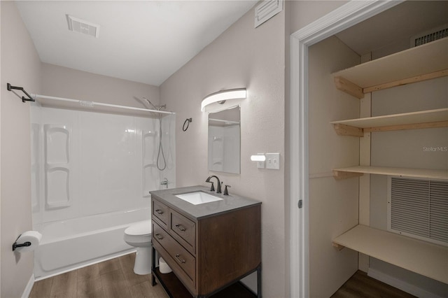 full bathroom featuring washtub / shower combination, wood-type flooring, vanity, and toilet