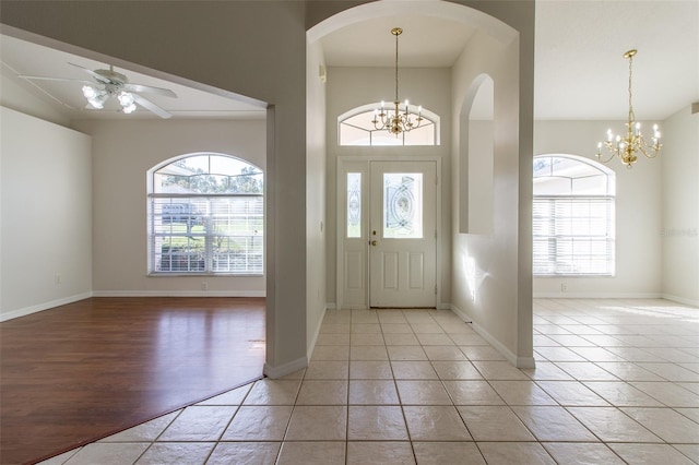 foyer with plenty of natural light, light hardwood / wood-style floors, and ceiling fan with notable chandelier