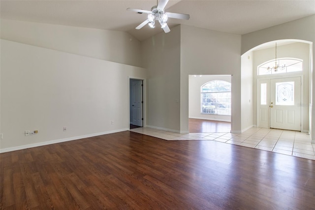 entryway featuring ceiling fan with notable chandelier, high vaulted ceiling, and light hardwood / wood-style flooring