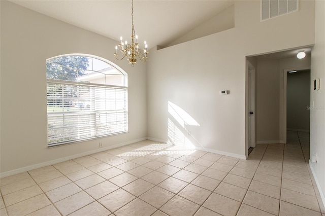 spare room with plenty of natural light, light tile patterned flooring, and lofted ceiling