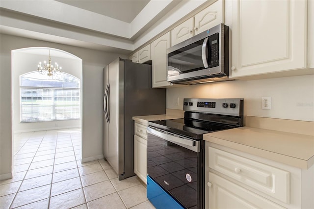 kitchen with light tile patterned flooring, hanging light fixtures, a notable chandelier, and appliances with stainless steel finishes