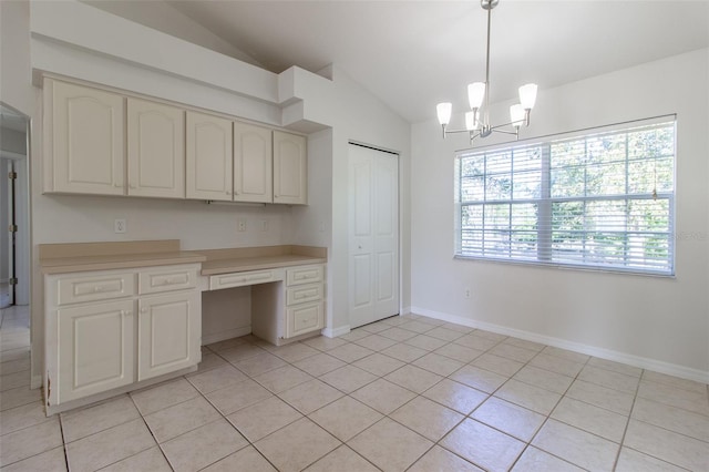 kitchen featuring hanging light fixtures, a chandelier, lofted ceiling, light tile patterned floors, and built in desk