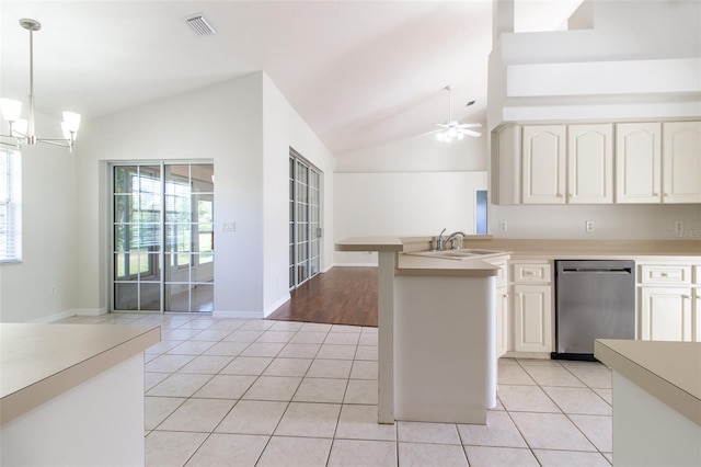 kitchen with stainless steel dishwasher, ceiling fan with notable chandelier, light tile patterned floors, hanging light fixtures, and lofted ceiling