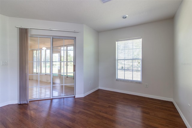 empty room featuring a textured ceiling and dark hardwood / wood-style flooring