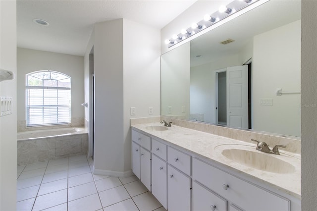 bathroom with vanity, tile patterned flooring, and a relaxing tiled tub