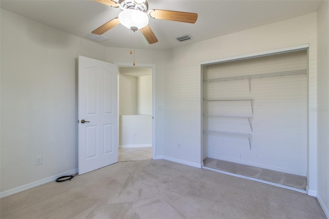 unfurnished bedroom featuring ceiling fan, a closet, and light carpet