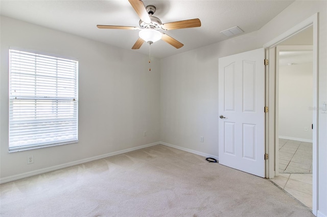 carpeted spare room featuring ceiling fan