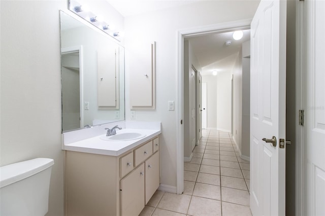 bathroom with toilet, vanity, and tile patterned floors