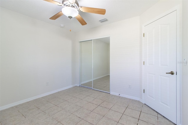 unfurnished bedroom featuring ceiling fan, a closet, and light tile patterned flooring