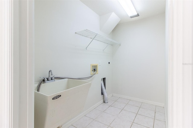 washroom featuring electric dryer hookup, light tile patterned floors, sink, and hookup for a washing machine