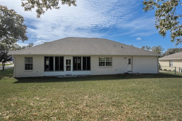 rear view of property featuring a lawn