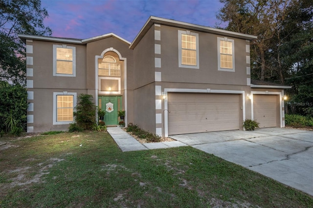 front of property featuring a lawn and a garage