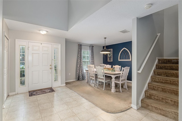 carpeted entrance foyer featuring a textured ceiling