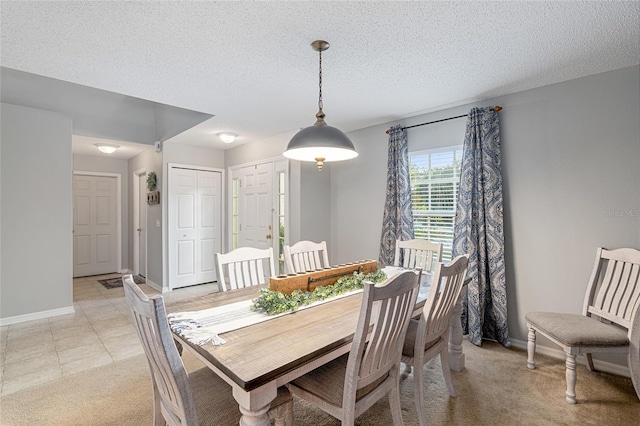 carpeted dining space with a textured ceiling