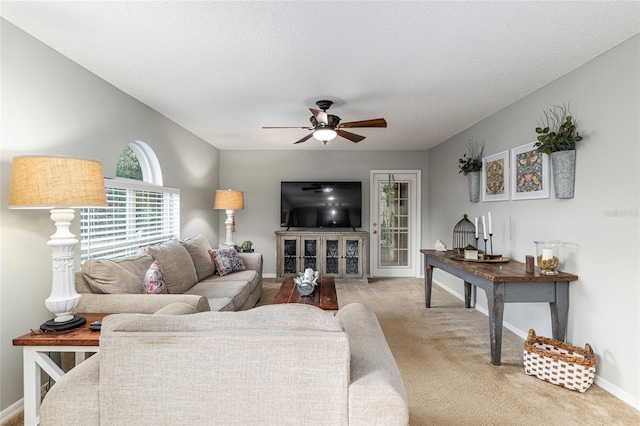 carpeted living room with ceiling fan and a textured ceiling