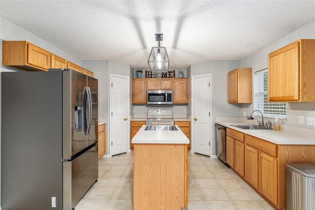 kitchen featuring a textured ceiling, sink, stainless steel appliances, and a kitchen island