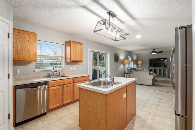 kitchen with sink, an island with sink, a healthy amount of sunlight, and appliances with stainless steel finishes