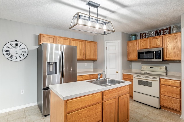 kitchen featuring appliances with stainless steel finishes, a textured ceiling, sink, pendant lighting, and a center island with sink