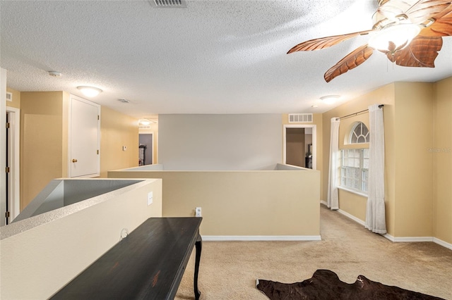 interior space featuring light carpet and a textured ceiling