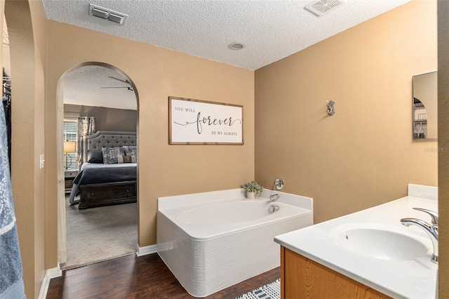 bathroom featuring wood-type flooring, a washtub, and a textured ceiling