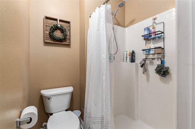 bathroom featuring toilet and a shower with shower curtain