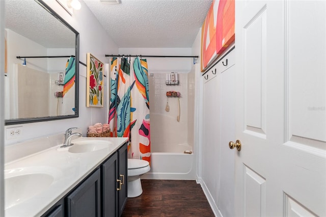 full bathroom with a textured ceiling, toilet, shower / bath combo with shower curtain, vanity, and hardwood / wood-style flooring