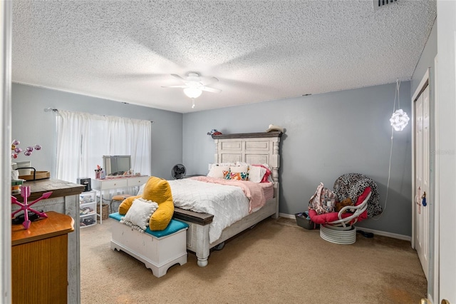 bedroom featuring ceiling fan, carpet floors, and a textured ceiling