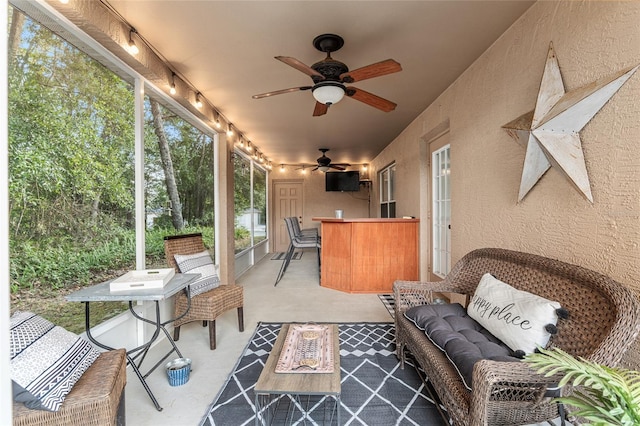 sunroom / solarium featuring ceiling fan