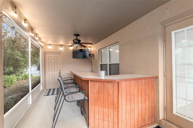 sunroom / solarium with ceiling fan and a hot tub