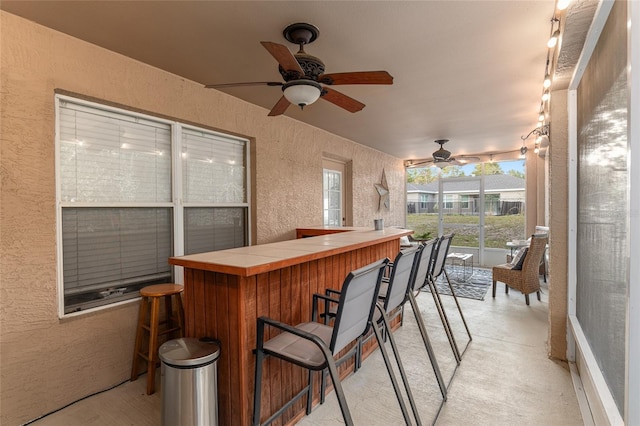 exterior space featuring ceiling fan, indoor bar, and a jacuzzi