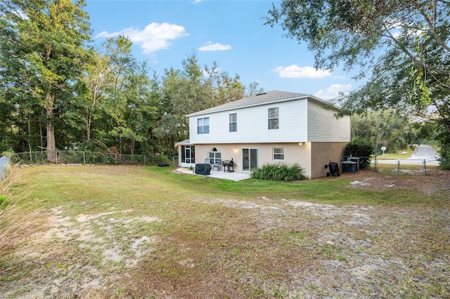 rear view of house featuring a lawn and a patio