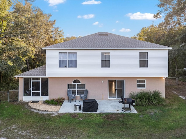 rear view of property featuring a lawn, a patio area, and a sunroom