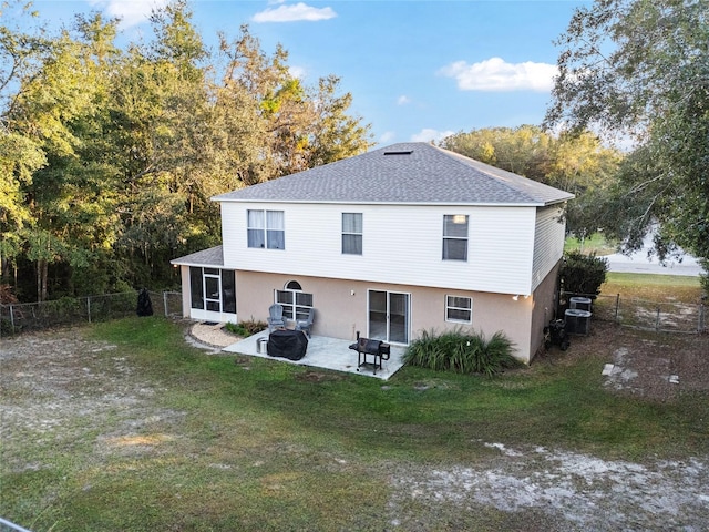 rear view of property with a lawn, a patio area, and a sunroom