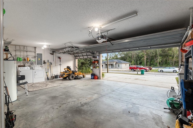 garage featuring water heater, electric panel, a garage door opener, and washer and dryer