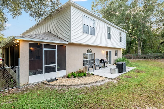 back of property featuring a patio area, a sunroom, and a yard