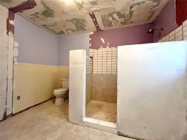 bathroom with toilet and tiled shower