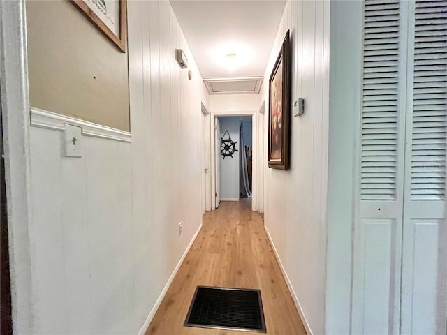 hallway with wooden walls and light hardwood / wood-style floors