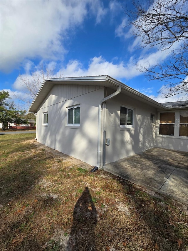 view of side of property with a yard and a patio