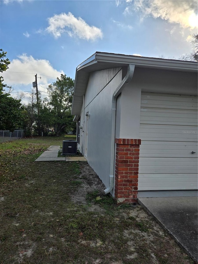 view of property exterior with cooling unit and a garage