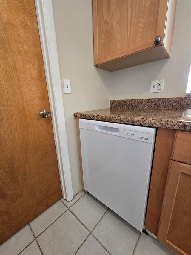 interior space with light tile patterned flooring and dishwasher