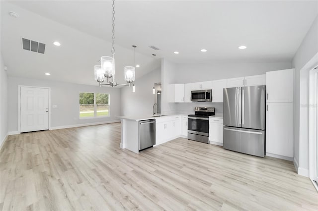 kitchen with kitchen peninsula, light wood-type flooring, stainless steel appliances, pendant lighting, and white cabinets