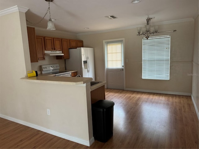 kitchen with pendant lighting, white appliances, a notable chandelier, crown molding, and light hardwood / wood-style floors