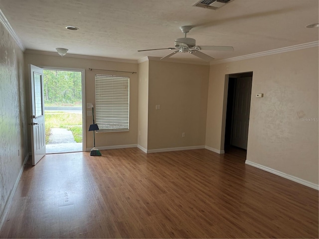 empty room featuring crown molding, ceiling fan, and dark wood-type flooring