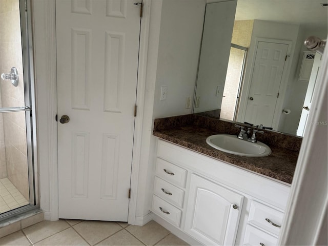 bathroom with tile patterned flooring, vanity, and a shower with door